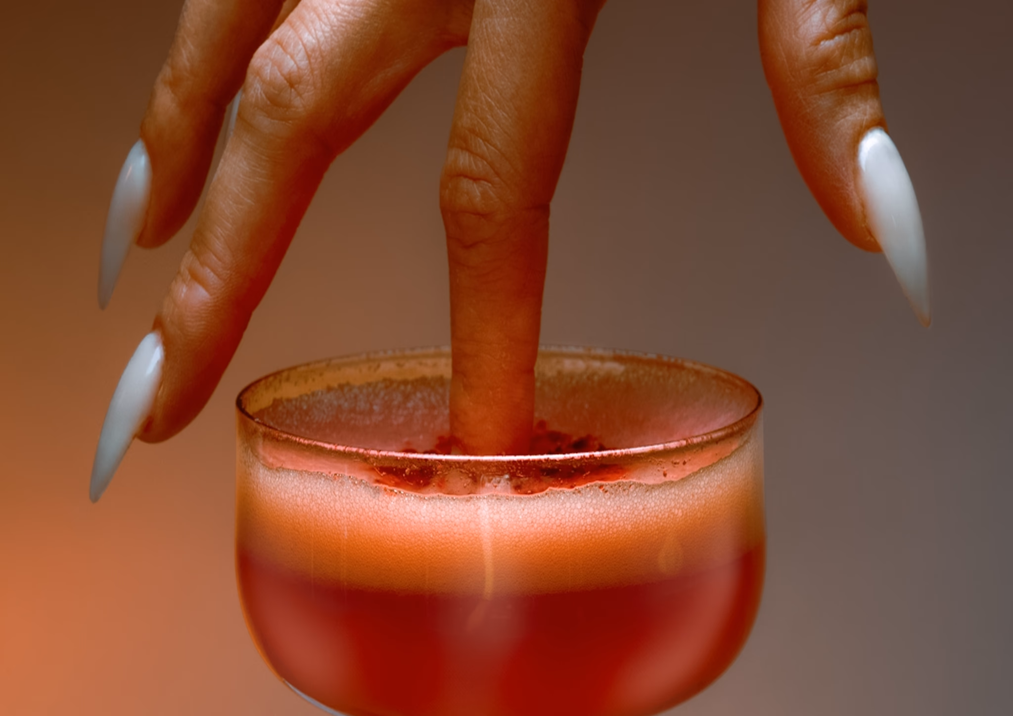 Hand dipping into a coral drink